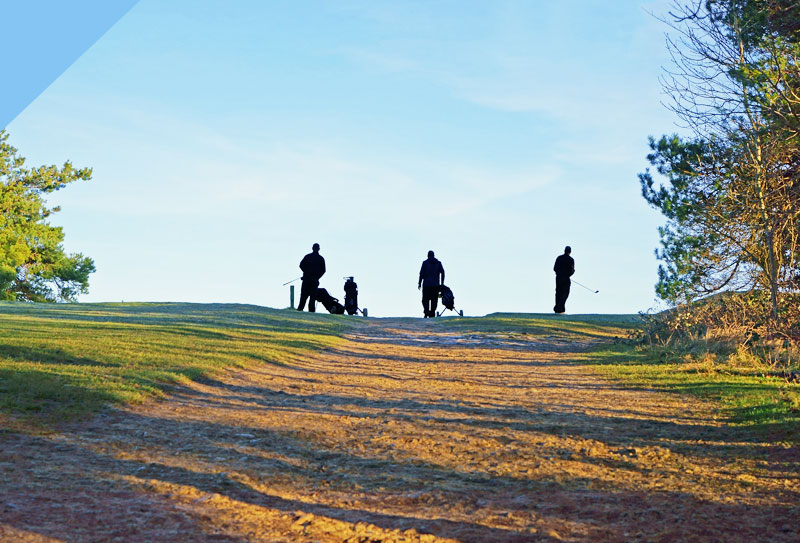 Three people Playing golf on a hill