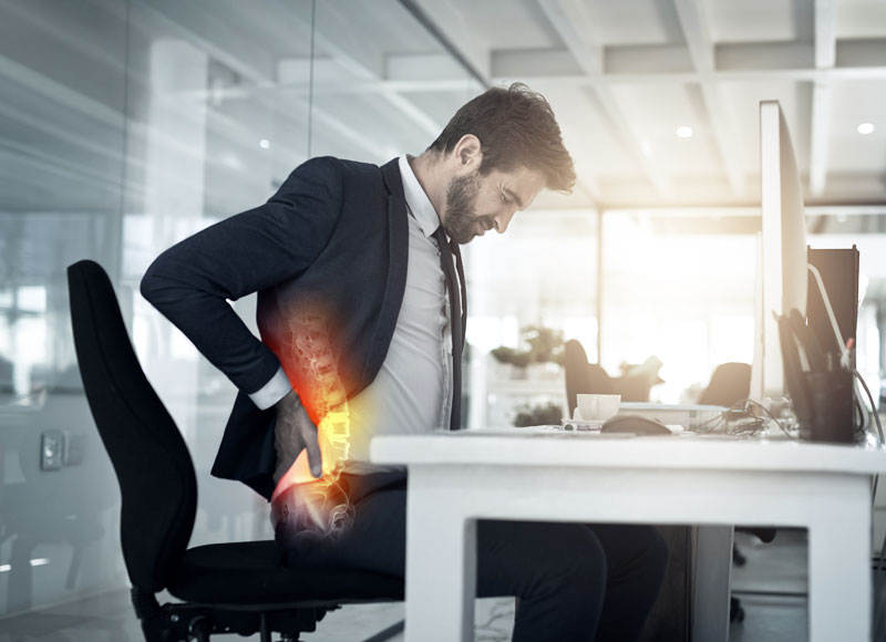 A Person suffering lower back pain due to a poor work posture